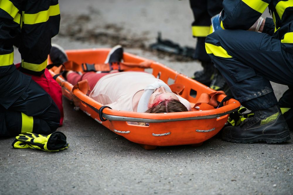 Firefighters helping an injured girl on the road